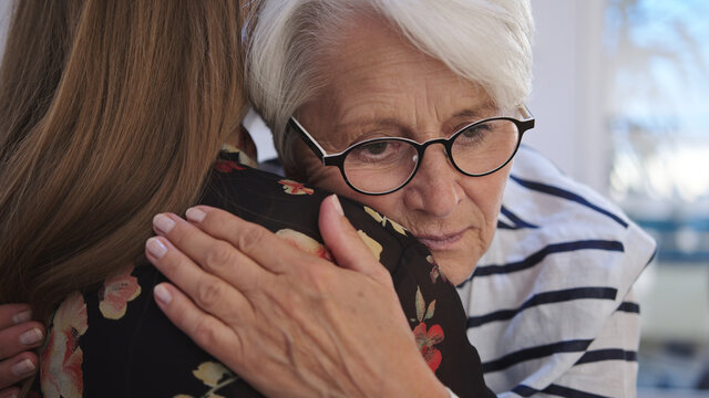 Young Woman Embracing An Elderly Lady. Grief And Bead News, Empathy Concept. High Quality 4k Footage