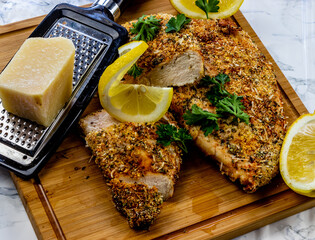 Itailain bread chicken with fresh lemon on a wooden cutting board. Calgary, Alberta, Canada