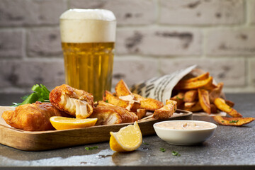 Fish and chips with beer on stone table