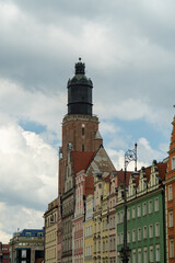 Obraz premium A tower in the center of the city, old tenement houses at the bottom.