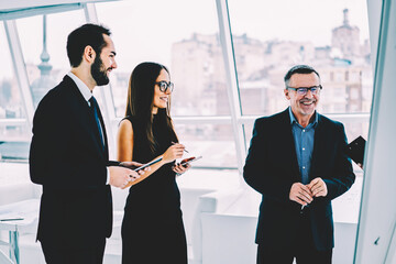 Matured entrepreneur satisfied with work f professional crew of marketing experts creating...