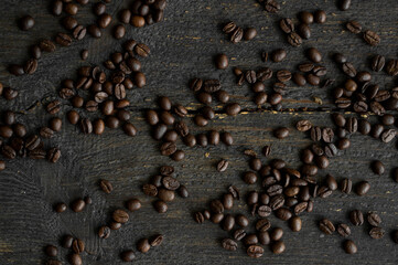 Roasted arabica coffee beans scattered on a wooden table. Fresh coffee beans.