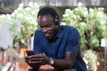 Mature man with headphones listening to music outdoors.