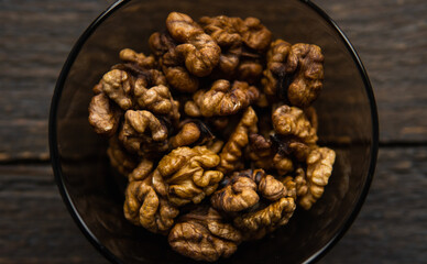 Walnut in a small plate on a vintage wooden table. Walnuts is a healthy vegetarian protein...
