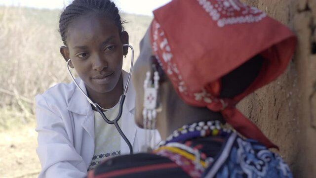Female doctor examining patient in rural community,  Kenya, Africa