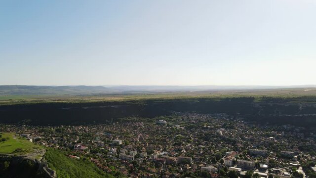 Aerial top view of a city down in valley, town Provadia in Bulgaria located between mountain hills