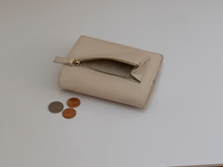 off white wallet open and a scattering of cents near the pocketbook. Isolated on a white background. Close up of a wallet with a shortage of coins