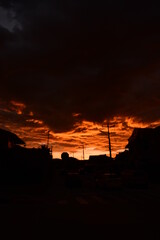 The sun is setting in a burnt orange sky as the city transforms into beautiful black silhouettes