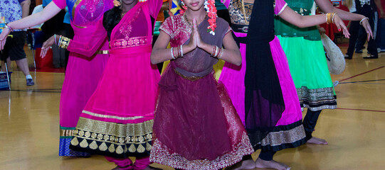 Young Indian girls preforming india dances at a heritage festival. Girls from India wearing colorful dresses dancing at a festival