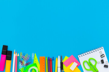 School colorful supplies border on blue, flatlay, top view, back to school, copy space, mockup