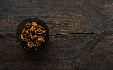 Walnut in a small plate on a vintage wooden table. Walnuts is a healthy vegetarian protein nutritious food. Natural nuts snacks.
