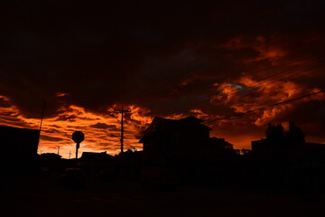 The sun is setting in a burnt orange sky as the city transforms into beautiful black silhouettes