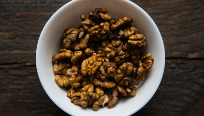 Walnut in a small plate on a vintage wooden table. Walnuts is a healthy vegetarian protein nutritious food. Natural nuts snacks.