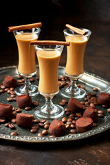 Chocolate truffles with creamy liquor on wooden board. Atmospheric food photo, selective focus