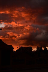 Fototapeta premium The sun is setting in a burnt orange sky as the city transforms into beautiful black silhouettes
