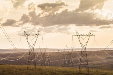 High voltage post. High-voltage transmission lines at sunset.
