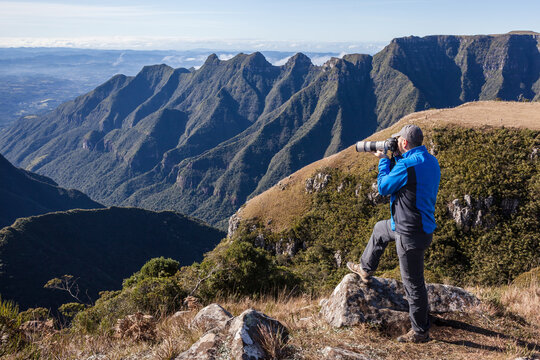 Man taking a photo of the cliffs of Ronda Canyon - Bom Jardim da Serra - SC - Brazil