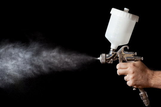 Close up of a spray paint gun with black background