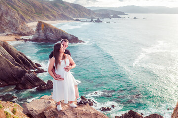 Pregnant couple on the edge of a cliff