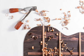 Back of guitar under construction with chisels and wood chips
