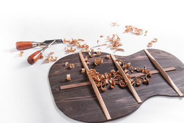 Back of guitar under construction with chisels and wood chips
