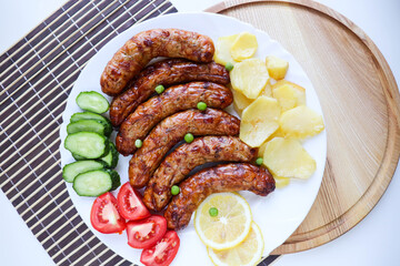 grilled sausages with vegetables on a white plate
