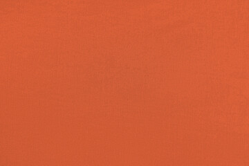 Red orange homogeneous background with a textured surface, fabric.