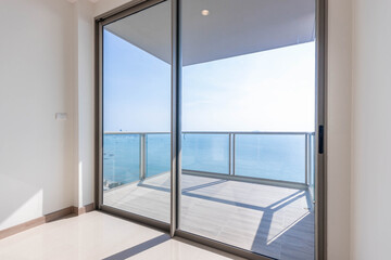 Big glass door and glasses balcony overlooks the sea.