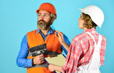 Discussing renovation with contractor. Couple planning changes renovation apartment. Renovation concept. Sign contract with workers. Price list. Couple look documents. Woman and man safety hard hat