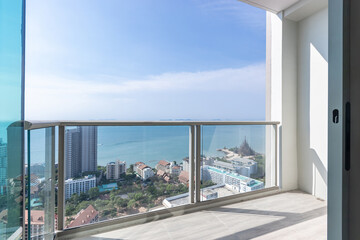 The glass balcony overlooks the sea and building.