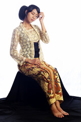 Beautiful Young Woman sits shyly and wears a kebaya. indonesian traditional costume. Portrait of...