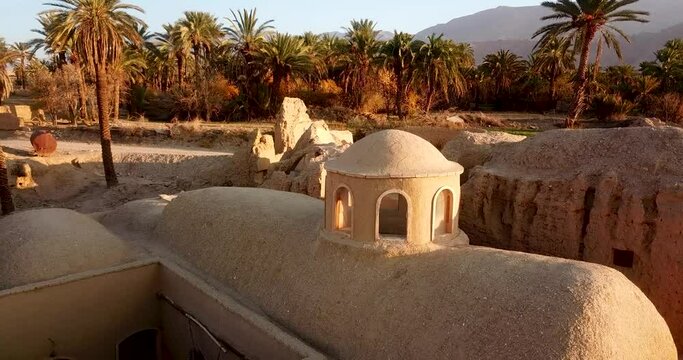 360 Degree over dome of an old mud house ruins resort in traditional desert Eco village and palm tree gardens and mountains landscape in back ground