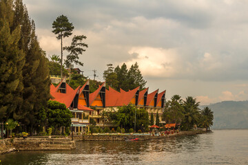 A row of Bataknese houses and villas on the shore of Lake Toba