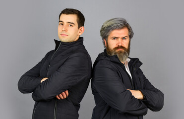 couple of men posing. two male have serious look. confidence and charisma. grey autumn colors....