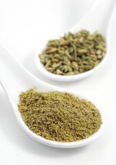 POWDER AND FENNEL SEEDS foeniculum vulgare AGAINST WHITE BACKGROUND