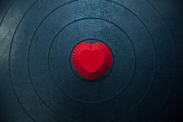 red silicone heart shape on a blue gymnastic ball close up