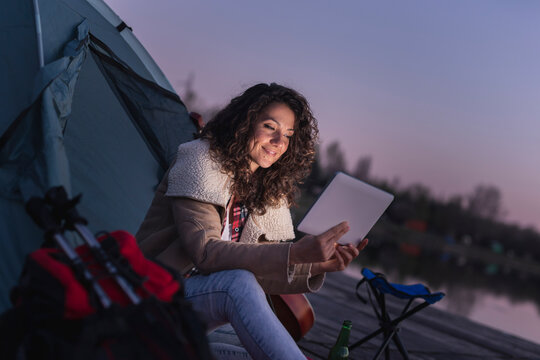 Woman using tablet computer while camping