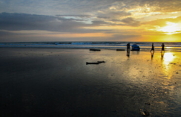 Sunset at beautiful beach at Canoa, pacific coast, Puerto Lopez, Manatí, Ecuador with silhouettes of people