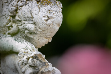 Baroque Statue against a red and green natural background in bokeh