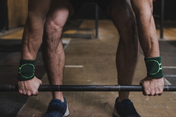 mano de atleta levantando barras con discos en el gimnasio