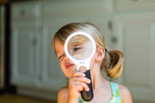 Young girl's eye close up through a magnifying glass