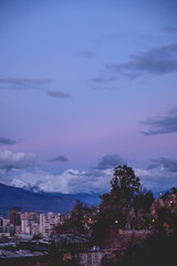 Beautiful panorama of purple and blue cloudy sunset sky over Santiago skyline, Santa Lucía Hill and Los Andes mountains, Chile