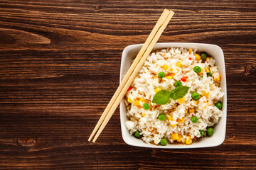 White rice with vegetables on wooden table