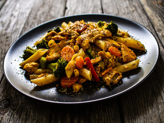 Chicken ragout with penne on wooden table
