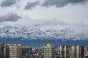 Amazing cloudy sky over Santiago skyline and the snowed Los Andes mountains, Chile