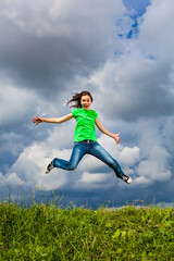 Girl jumping, running against cloudy sky

