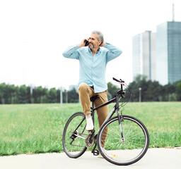Obraz premium senior man smartphone bicycle cycling cell mobile phone outdoor city park businessman business casual