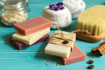 Spa lifestyle with colored natural soap, towels and a dry massage brush. On a blue wooden background