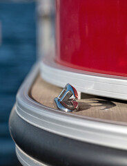 Detail of a rope cleat on the front end of a red pontoon, with selective focus with shallow depth...