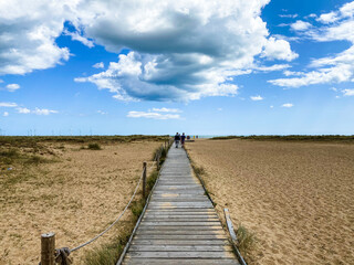 Obraz premium Great Yarmouth beach in a summer day, traditional UK English East Coast landscape, blue and brown, sky with clouds no people, large stretch of sand, UK beaches
